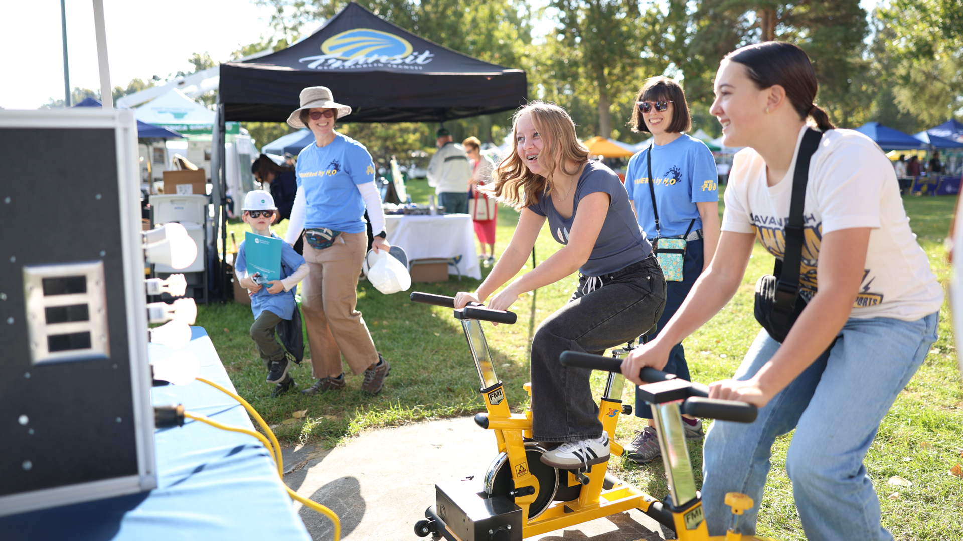 Kids riding the pedal power energy generating bikes