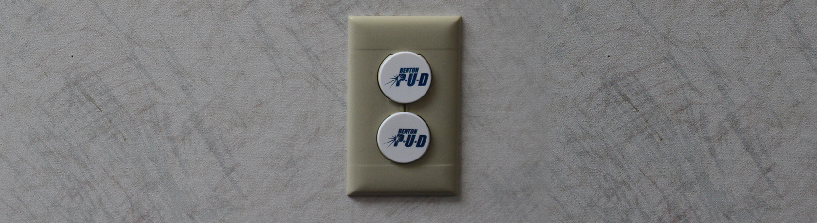 Photograph of an electrical outlet with Benton PUD outlet covers.